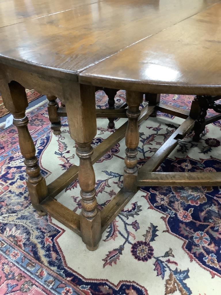 An 18th century style oval oak gateleg dining table, length 150cm extended, width 122cm, height 75cm